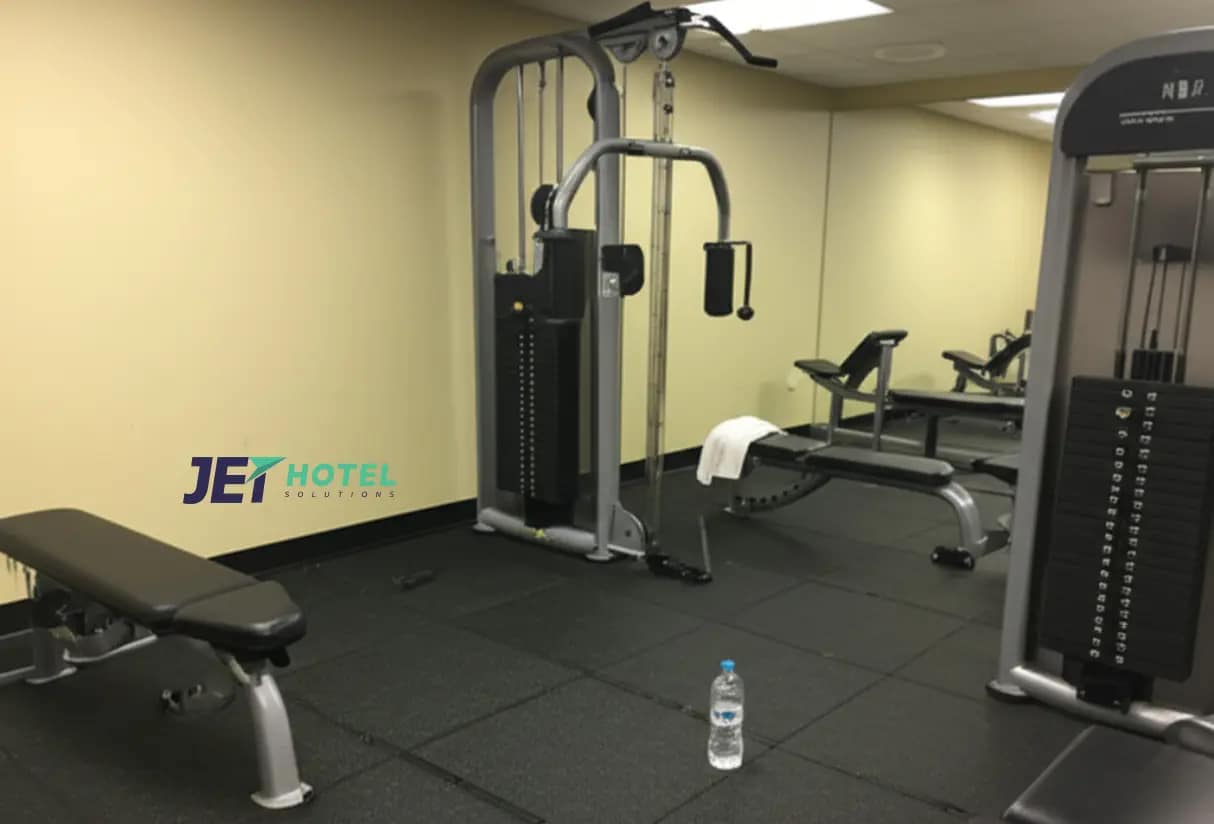 A guest snaps a quick, slightly blurry selfie mid-workout in a hotel gym, with the cable machine in the background, capturing the real, unpolished vibe of staying active on the road.