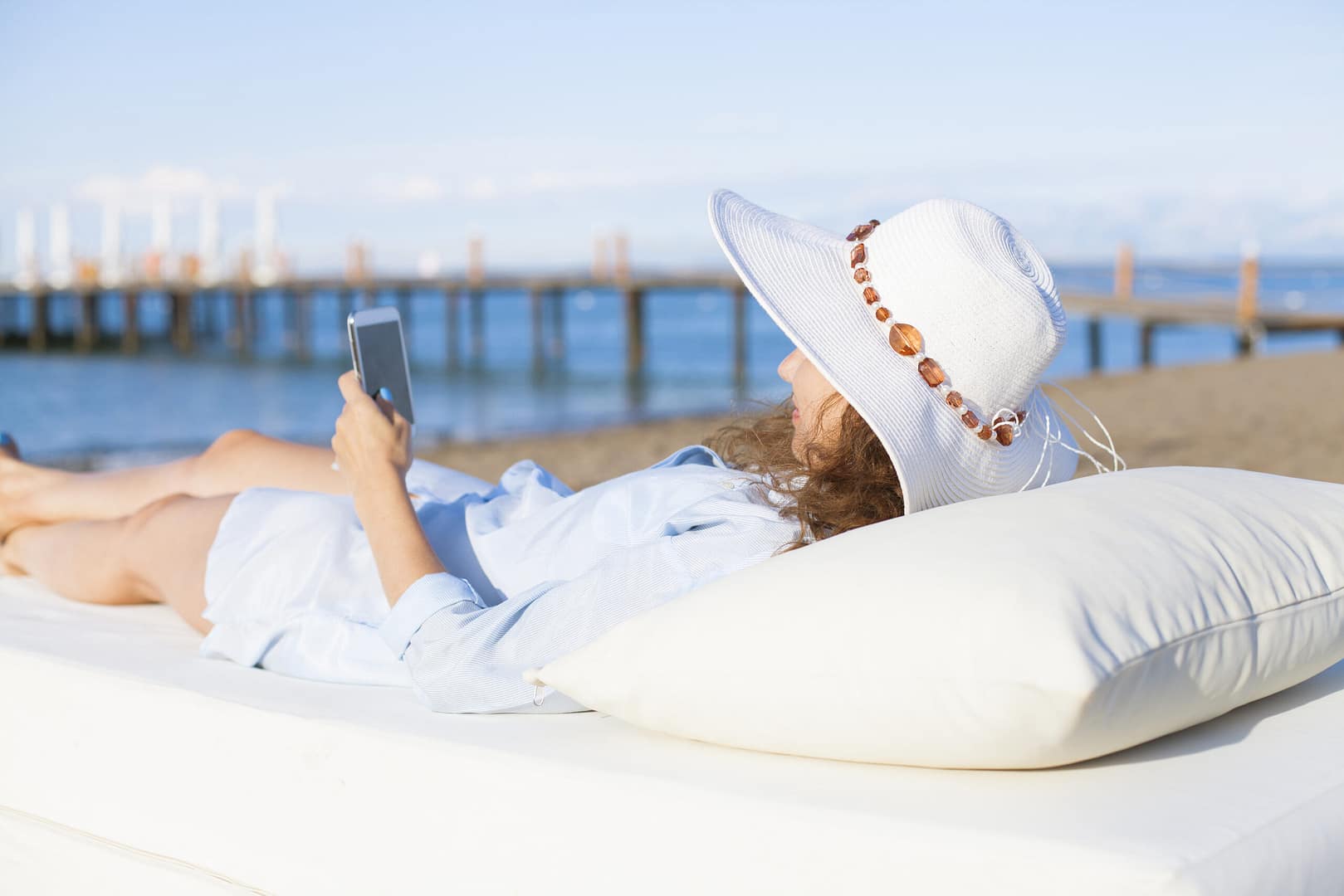 Young,Woman,At,The,Beach,Using,Her,Cell,Phone Hotel technology push notifications 2