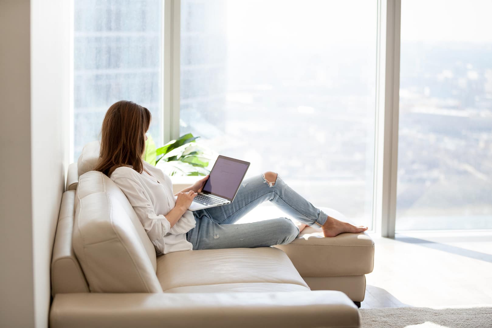 Relaxed,Woman,Using,Laptop,In,Luxury,Home,Living,Room,With hotel technology