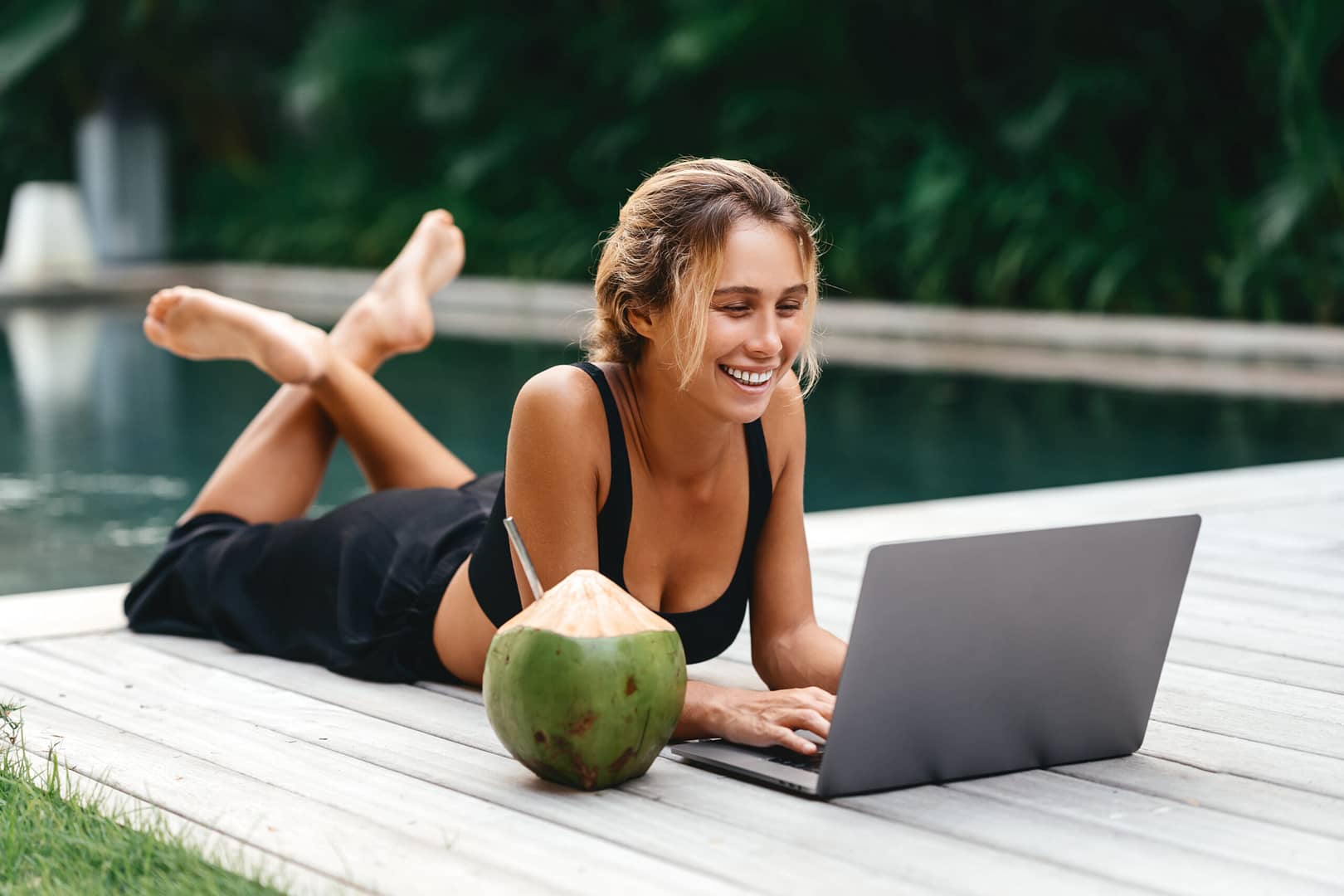 Attractive,Young,Female,Sitting,In,The,Swimming,Pool,And,Working eco-friendly hotels 3